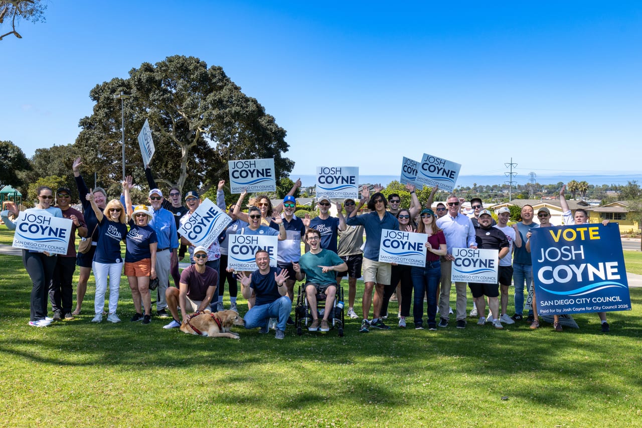Josh Coyne with the campaign team of neighbors and volunteers, holding Josh Coyne for San Diego City Council signs after a day of canvassing.